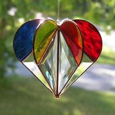 three heart shaped stained glass ornaments hanging from a string