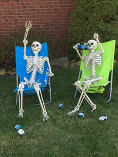 two lawn chairs with skeletons sitting in the grass, one holding a beer bottle and the other standing up