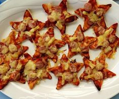 a white plate topped with cheesy food on top of a blue table cloth