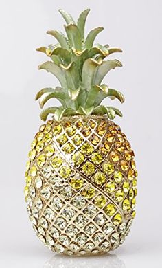 a pineapple shaped object with yellow and green crystals on it's side, against a white background