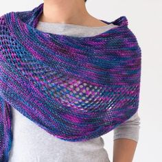 a woman wearing a purple and blue knitted shawl