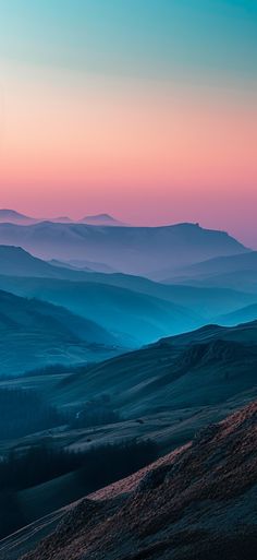 the mountains are covered in fog at sunrise or sunset, and there is no image here to provide a caption for