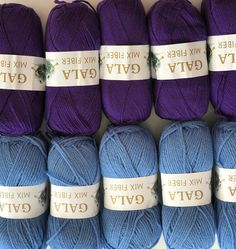 several balls of blue and purple yarn are lined up