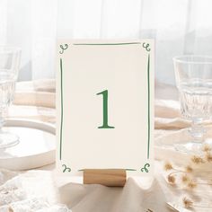 a table setting with place cards and wine glasses