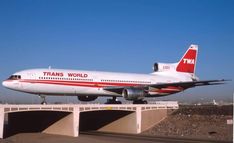 an airplane that is sitting on top of a runway at an airport with the word trans world painted on it