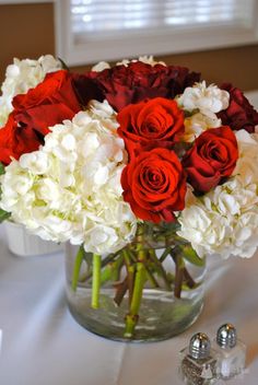 a vase filled with red and white flowers