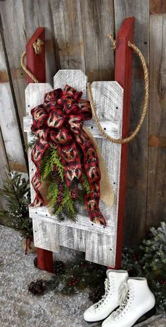 a pair of white ice skates sitting on top of a wooden bench next to a christmas tree