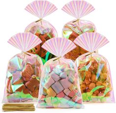 three bags filled with candy and small parasols on top of each bag, all in iridescent colors