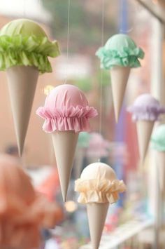 several ice cream cones are hanging from strings