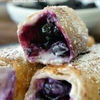 blueberry turnovers stacked on top of each other with powdered sugar in the middle