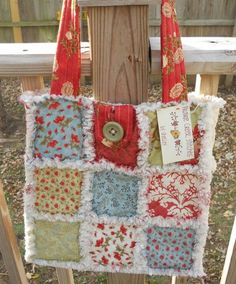 a handbag hanging from a wooden fence in front of a fence post with a tag on it