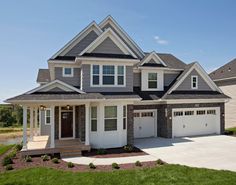 a large gray and white house with two garages