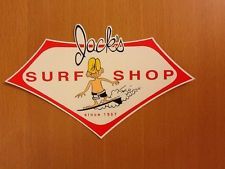 a surf shop sign on the side of a wooden door