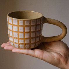 a hand holding a coffee cup in it's palm