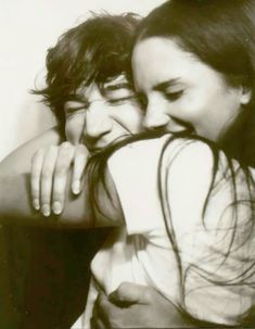 two people are hugging each other in black and white