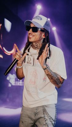 a man with dreadlocks holding an umbrella in front of his face while standing on stage