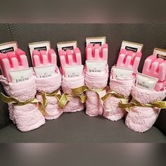 pink baby booties with gold ribbon and tags on them are sitting next to each other