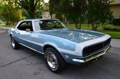 a blue and white muscle car parked on the street