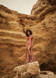 a woman standing on top of a rock formation