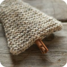 a knitted object with cinnamon sticks sticking out of it's end on a wooden surface