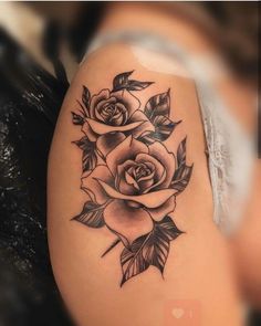 a black and white photo of a rose tattoo on the side of a woman's thigh