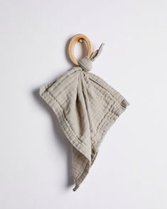 a wooden ring hanging from the side of a gray and white cloth baby bib