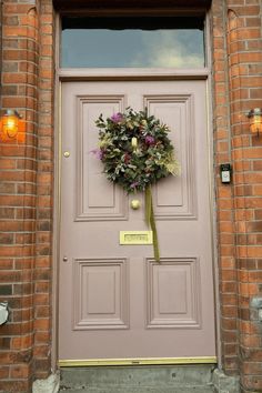 a pink door with a wreath on it