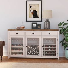 a dog is looking at the wine bottles on the sideboard