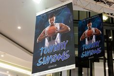 two banners hanging from the ceiling in front of a building with an advertisement for tommy simmons