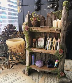 a book shelf made out of wood with moss growing on it and candles in the middle