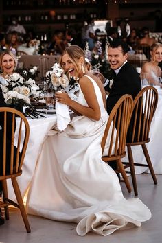 a bride and groom sitting at a dinner table