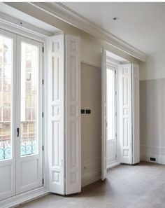 an empty room with white doors and windows