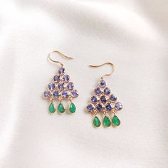 These stunning earrings are set in 14k Solid Yellow Gold with Natural Tanzanite and Emerald with utmost precision. It is an unique and dainty gemstone earring pair for nearly every occasion and is completely hassle-free jewelry. ITEM DETAILS: * Gem: Tanzanite * Gem Size: 4X4 mm (20pcs) * Gem Shape: Round * Gem Weight: 7.46 carats * Gem: Emerald * Gem Size: 4X7 mm (6pcs) * Gem Shape: Pear * Gem Weight: 2.23 carats * Gold Purity: 14KT * Gold Weight: 2.553 gram * Total Weight of the Earrings: 4.491 Formal Multi-stone Drop Earrings, Formal Multi-stone Dangle Earrings, Multi-stone Drop Earrings For Evening, Yellow Gold Multi-stone Party Earrings, Elegant Multi-stone 14k Gold Earrings, Party Multi-stone Yellow Gold Earrings, Evening Multi-stone Drop Earrings, Briolette Earrings With 17 Jewels As Gift, Green Briolette Earrings For Anniversary