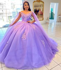 a woman in a purple ball gown posing for the camera