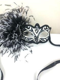 "Feather mask- NYC -Masked ball- New Years Eve- White and black Masquerade Ball- Mardi Gras -Halloween Hello, Made and ready to ship in 1-2 business days. Perfect for a masquerade party, birthday celebration, costume party, New Years Eve celebration or Mardi Gras. These feathers are on the side of a plaster mask that's black and white with some glitter. A beautiful brooch sets it all off! Made with a black sparkle tie. The feathers are about 6\" long. It's on a very comfortable mask...ages 16 an Black Eye Mask For Masquerade, Elegant Black Mask For Costume Party, Halloween Evening Masquerade Mask, Carnival Evening Masquerade Eye Mask, Gothic Masquerade Eye Mask, Gothic Style Masquerade Eye Mask, Gothic Eye Mask For Masquerade, Black Eye Mask For Evening Masquerade, Black Masquerade Mask For Carnival Costume Party