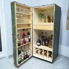 an open wine cooler filled with bottles and glasses