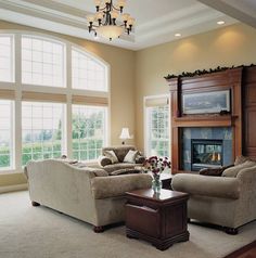 a living room with two couches and a coffee table in front of a fireplace