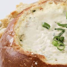 a bread bowl filled with cheese and green onions