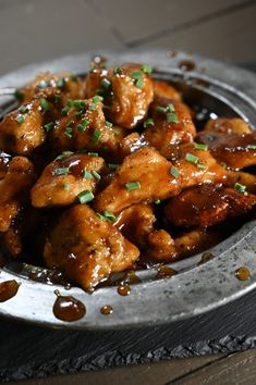 a metal plate topped with chicken covered in sauce