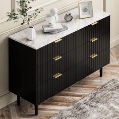 a black and white marble top dresser with brass pulls on it's drawers in a living room