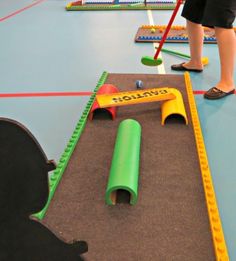 children playing with toys on the floor in an indoor play area at a child's school