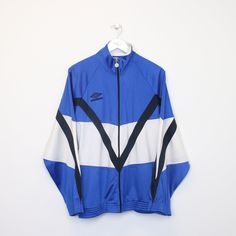 SKU - AT5613  Vintage Umbro track jacket in blue, white and black. Best fits L  DETAILS: ▫️ Full zip up  ▫️ Front stitched logo    👕 Fits like a ~ L ▫️ Label states ~ L ▫️ Pit to Pit ~ 25.5" ▫️ Length ~ 26" ▫️ Pit to Cuff ~ 19"   👇 If any defect is found and it is not included in the provided photos, it will be listed below. ▫️    🧺 All items are professionally washed and ironed before photos are taken and then sold.    ✅ If the item is listed, it is available    ❌ Disclaimer: Like all vintag Casual White Training Outerwear, White Casual Outerwear For Training, Casual White Outerwear For Training, Blue Sportswear Track Jacket For Sports Events, Blue Track Jacket For Sports Events, White Crew Neck Sporty Track Jacket, Blue Long Sleeve Training Outerwear, Blue Long Sleeve Outerwear For Training, Technical Long-sleeve Track Jacket For Streetwear