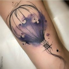 a watercolor tattoo on the arm of a woman with an air balloon in it