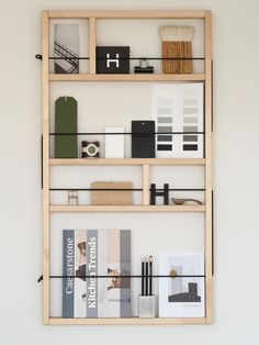 a book shelf with books and other items on it, mounted to the wall in front of a white wall