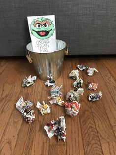 a bucket filled with candy sitting on top of a wooden floor next to a sign