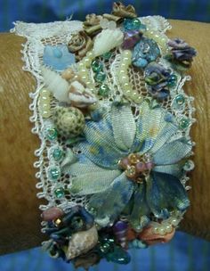 a close up of a person's arm wearing a bracelet with shells and beads