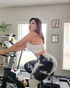 a woman is riding on a stationary bike