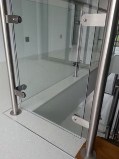 a glass shower door in a bathroom next to a toilet paper dispenser