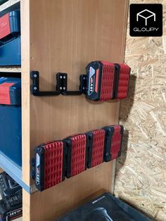 two red and blue tool holders are on the wall