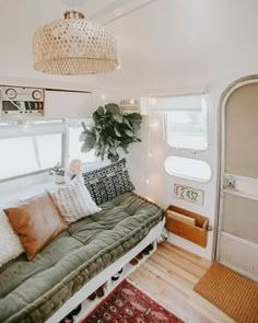 a living room with a couch, rug and potted plant on the wall next to it